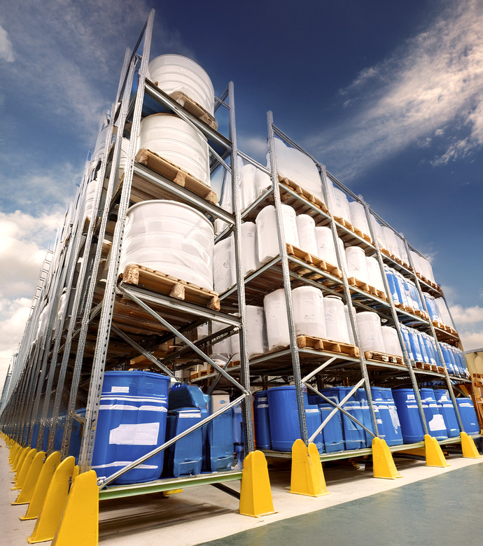 Estantes metálicos de un almacén exterior con bidones de grandes dimensiones con material médico