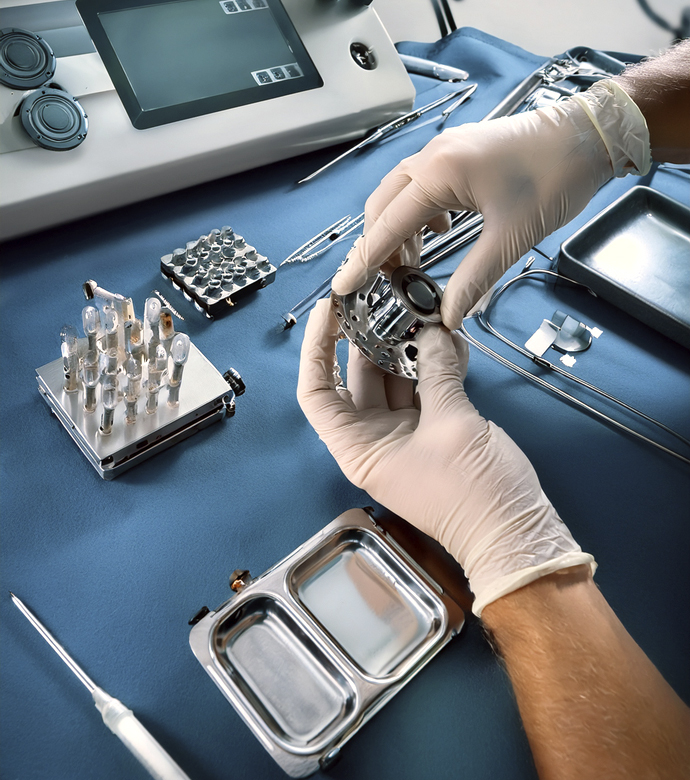 Manos instalando una pieza de repuesto en un dispositivo sanitario.